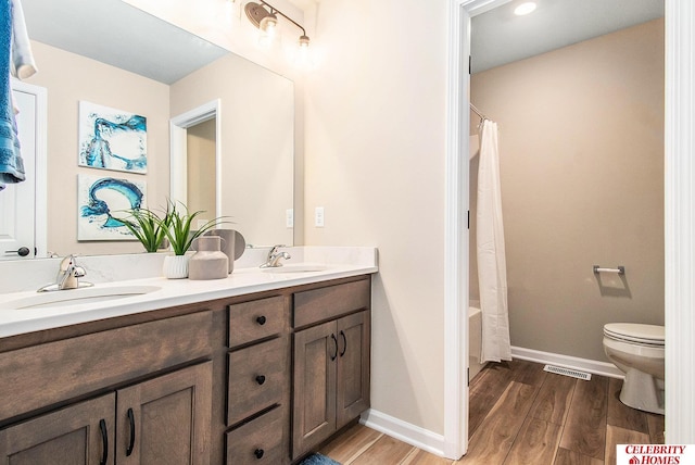 full bathroom with vanity, shower / tub combo with curtain, and toilet