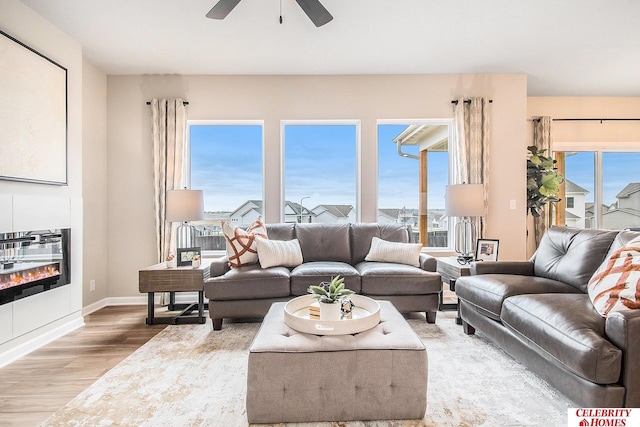 living room featuring heating unit, hardwood / wood-style flooring, and ceiling fan