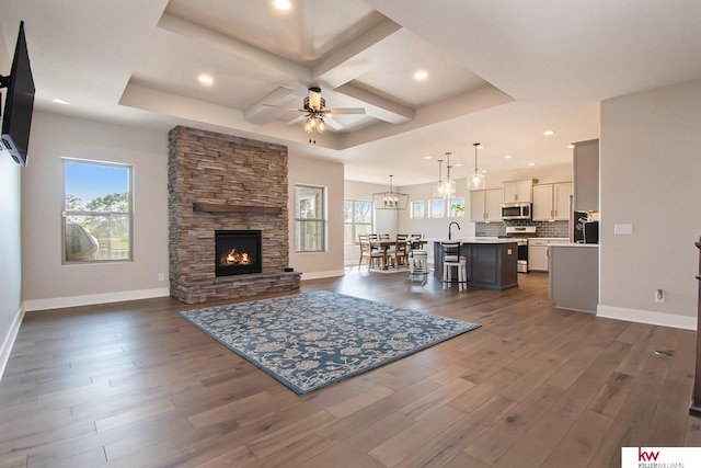 living room featuring dark hardwood / wood-style floors, a healthy amount of sunlight, coffered ceiling, and ceiling fan