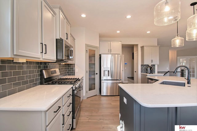 kitchen with appliances with stainless steel finishes, a large island, pendant lighting, and sink