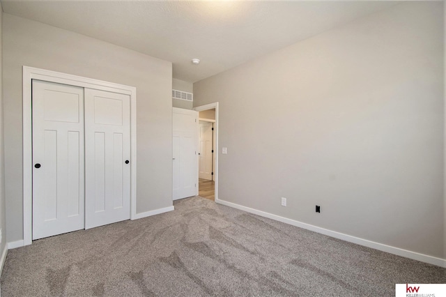 unfurnished bedroom featuring light colored carpet and a closet