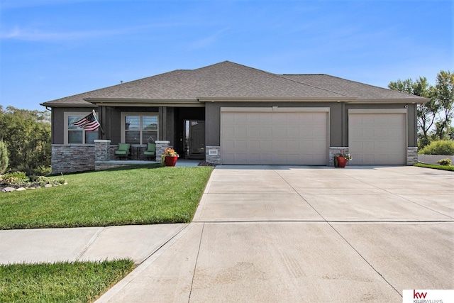 prairie-style house featuring a garage and a front yard