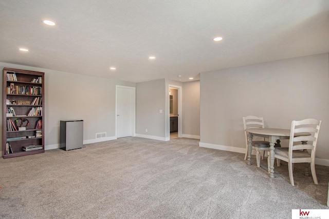 interior space featuring light colored carpet and a textured ceiling