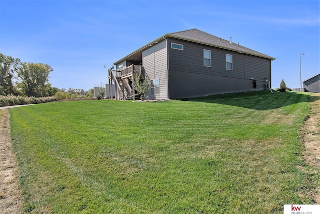 view of side of home featuring a wooden deck and a lawn