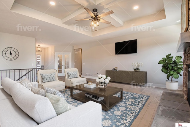 living room featuring french doors, ceiling fan, a raised ceiling, and beamed ceiling