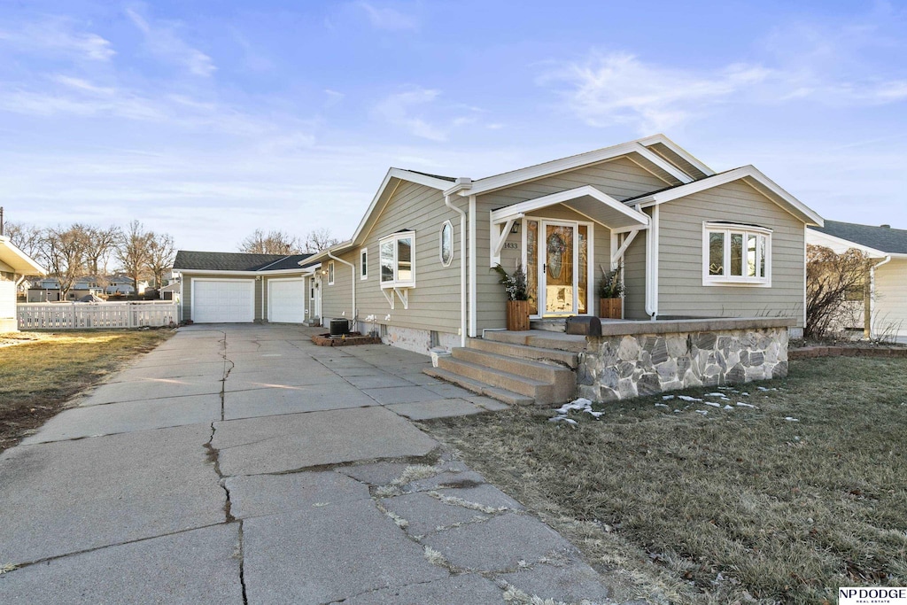 view of front of house with a garage, central AC, and a front yard