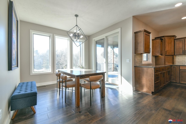 dining area featuring dark hardwood / wood-style flooring and an inviting chandelier