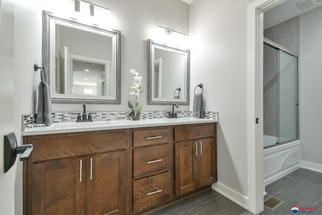 bathroom with bath / shower combo with glass door, vanity, and decorative backsplash