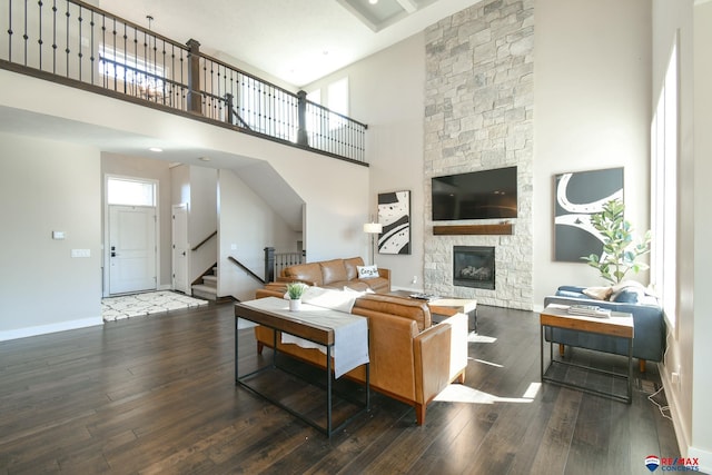 living room with a fireplace, dark hardwood / wood-style flooring, and a high ceiling