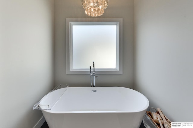 bathroom with a bathtub and a notable chandelier