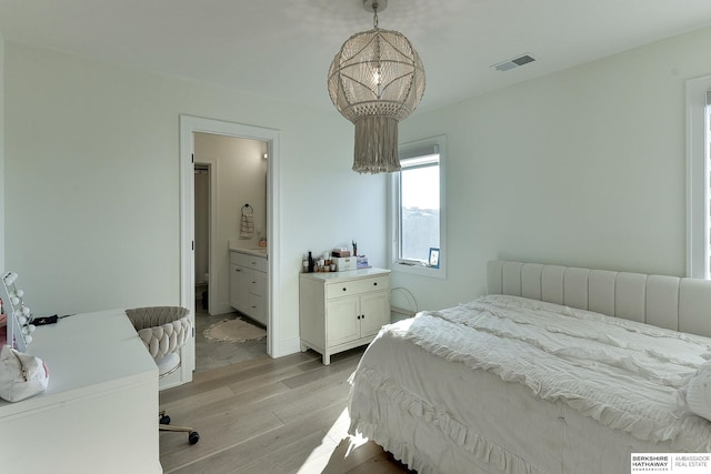 bedroom with an inviting chandelier and light hardwood / wood-style floors