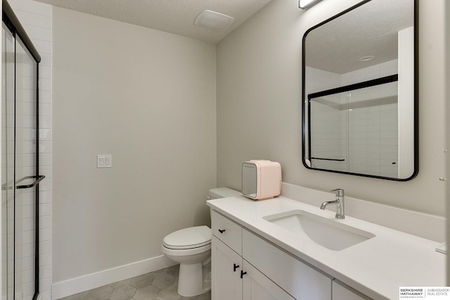 bathroom with vanity, a textured ceiling, toilet, and walk in shower