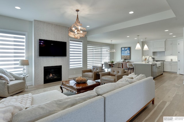 living room with a large fireplace and light hardwood / wood-style flooring