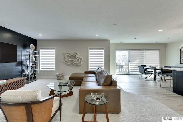 living room featuring light hardwood / wood-style floors and wood walls