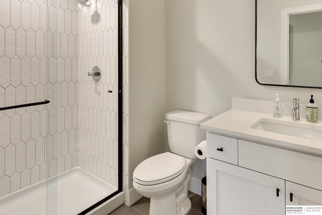 bathroom with vanity, tile patterned floors, toilet, and tiled shower