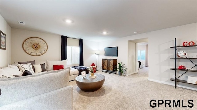 living room featuring plenty of natural light and light carpet