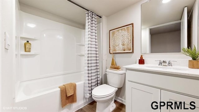 full bathroom with shower / bath combo, hardwood / wood-style floors, vanity, and toilet