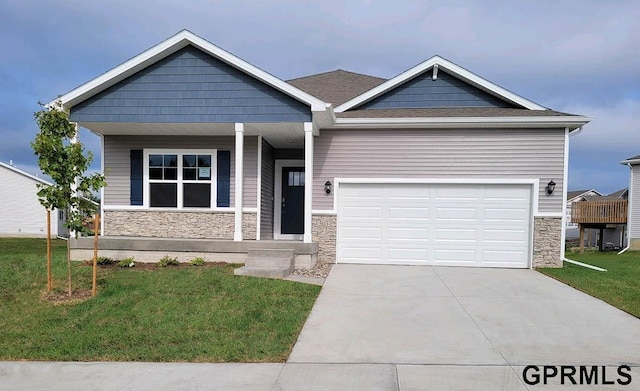 craftsman inspired home featuring a garage and a front lawn