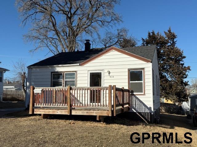 back of house featuring a lawn and a deck