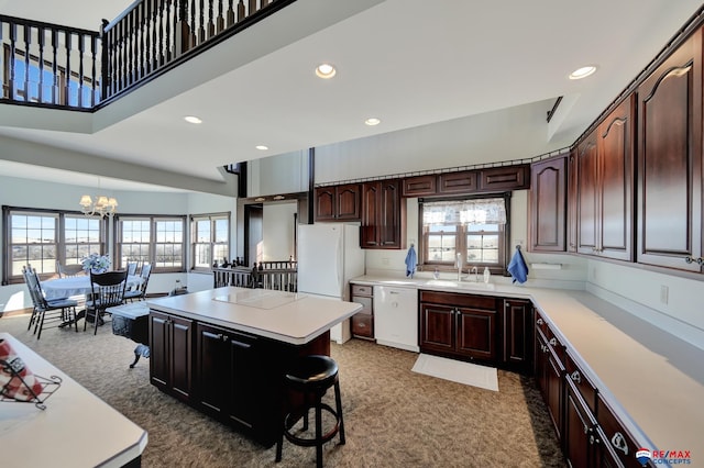 kitchen featuring light countertops, white appliances, a healthy amount of sunlight, and a center island