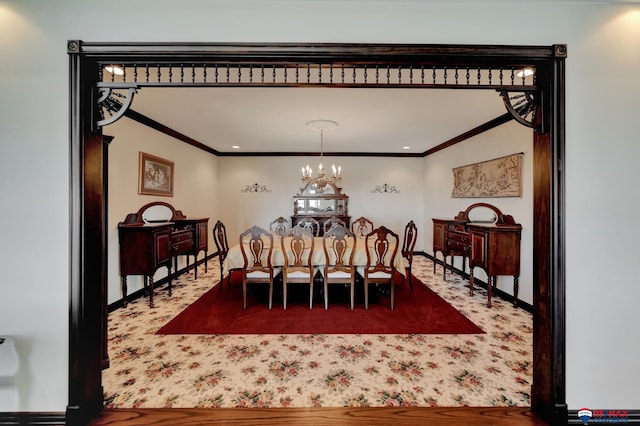 carpeted dining area with an inviting chandelier, baseboards, and ornamental molding