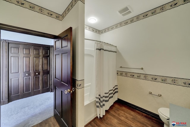 full bathroom with toilet, shower / bath combo, wood finished floors, and visible vents