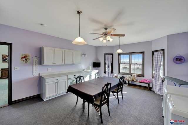 carpeted dining room with a sink and a ceiling fan