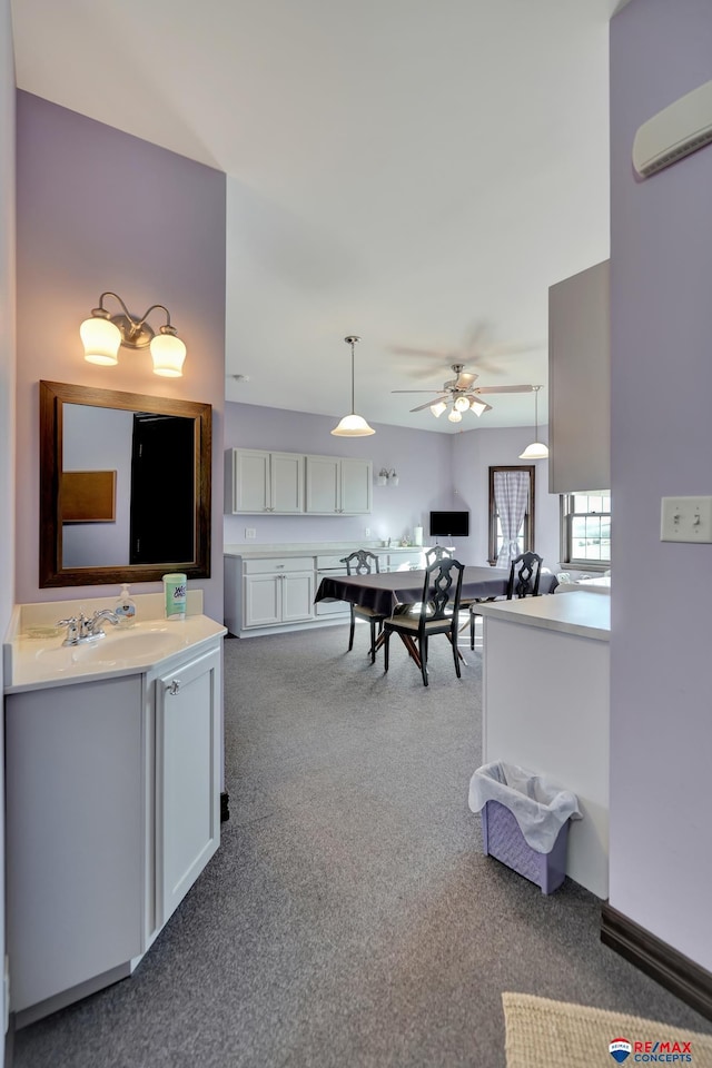 interior space featuring ceiling fan, a wall mounted air conditioner, and a sink