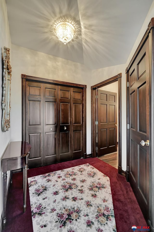 entryway featuring dark carpet and baseboards