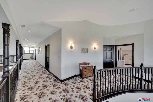 corridor featuring baseboards, an upstairs landing, visible vents, and light colored carpet