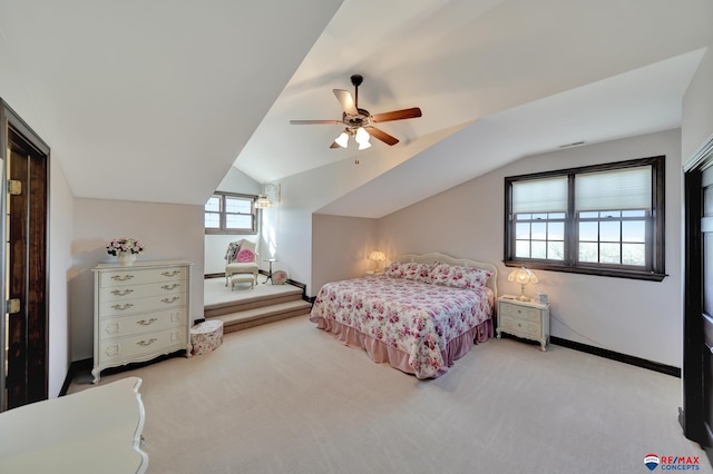 bedroom with lofted ceiling, ceiling fan, baseboards, and light colored carpet