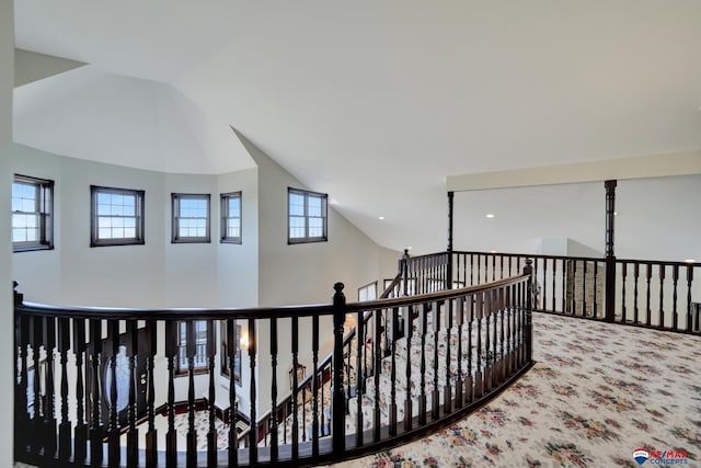 corridor featuring lofted ceiling and carpet