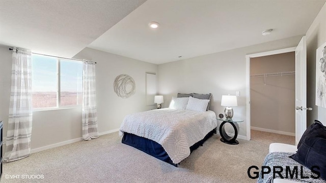 carpeted bedroom featuring a spacious closet and a closet