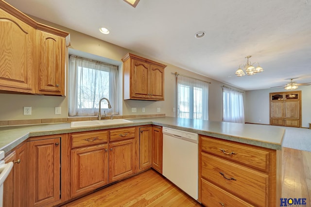 kitchen with sink, dishwasher, hanging light fixtures, a wealth of natural light, and kitchen peninsula