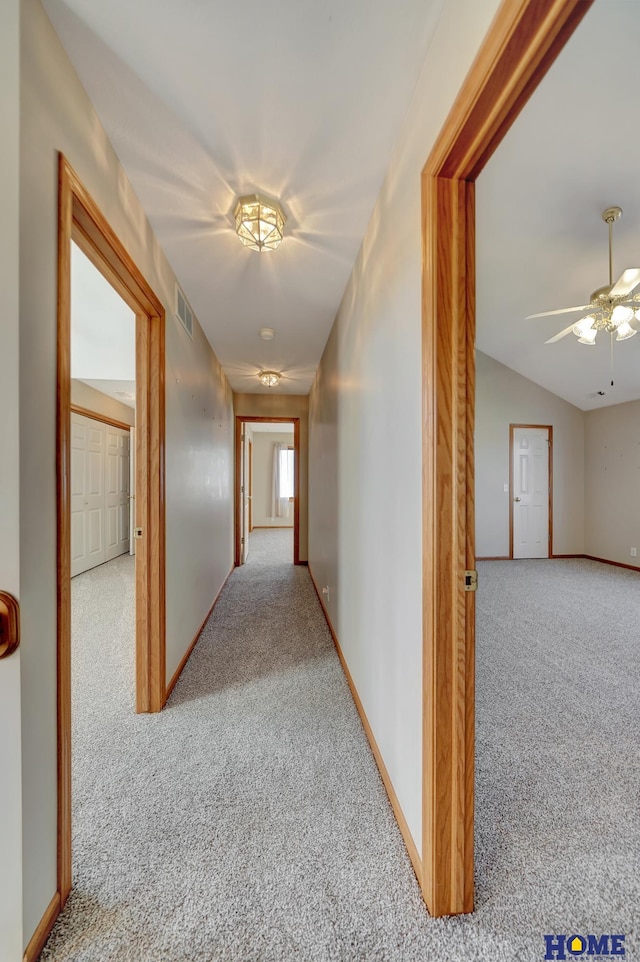 hall with light colored carpet and lofted ceiling