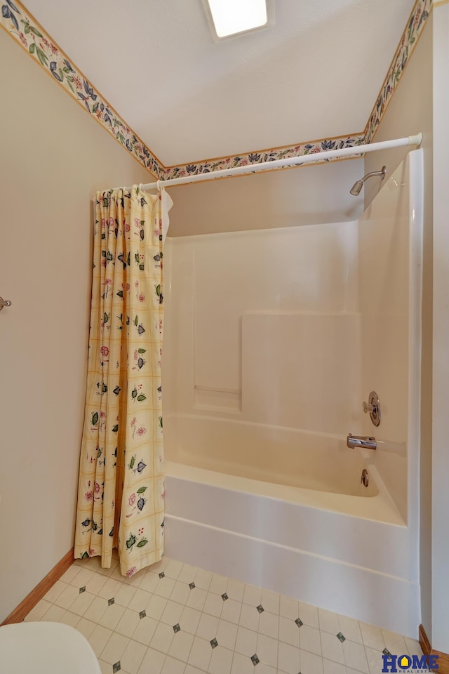 bathroom featuring shower / bath combination with curtain, tile patterned floors, and toilet