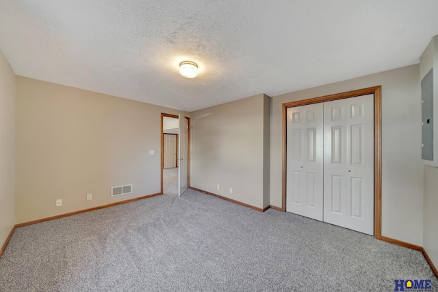 unfurnished bedroom featuring a closet, carpet flooring, and a textured ceiling