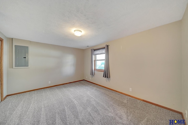 spare room with carpet floors, electric panel, and a textured ceiling