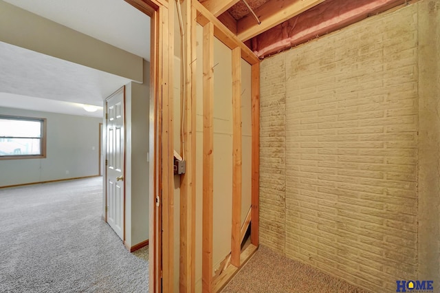 interior space featuring light colored carpet and brick wall