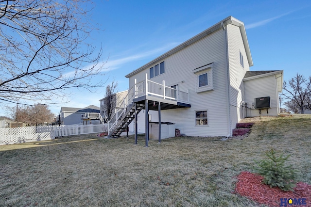 rear view of property with a wooden deck and a lawn