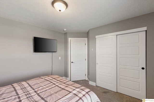 unfurnished bedroom featuring dark colored carpet, a textured ceiling, and a closet