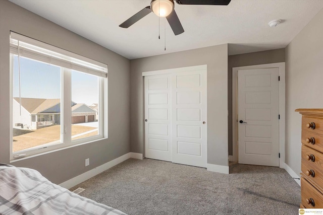 unfurnished bedroom featuring a closet, ceiling fan, and carpet