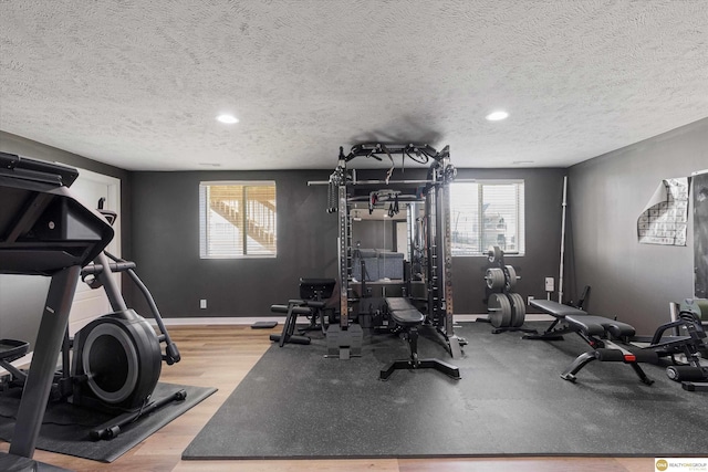 workout area featuring hardwood / wood-style floors and a textured ceiling