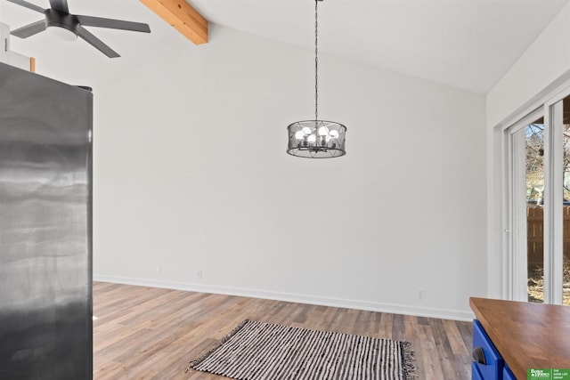 unfurnished dining area with ceiling fan with notable chandelier, lofted ceiling with beams, and light hardwood / wood-style flooring