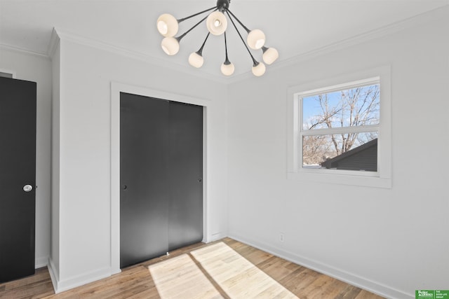 interior space featuring crown molding, light wood-type flooring, and a chandelier