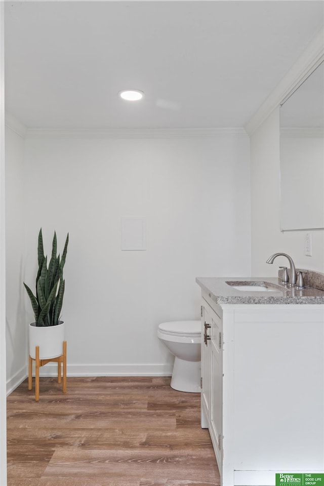 bathroom with crown molding, vanity, toilet, and hardwood / wood-style flooring