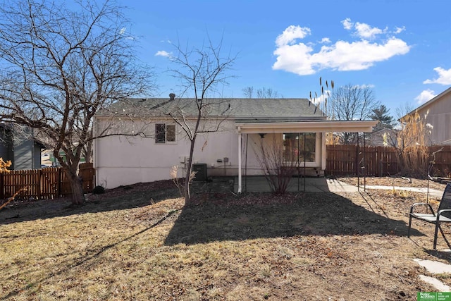 rear view of property with central AC and a yard