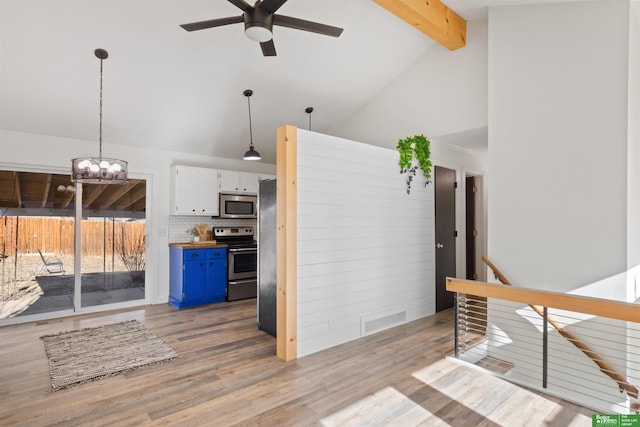 kitchen featuring white cabinets, hanging light fixtures, stainless steel appliances, blue cabinetry, and beam ceiling