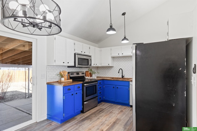 kitchen featuring sink, wooden counters, decorative light fixtures, appliances with stainless steel finishes, and white cabinets