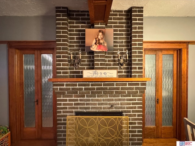 details with a textured ceiling, a fireplace, and french doors